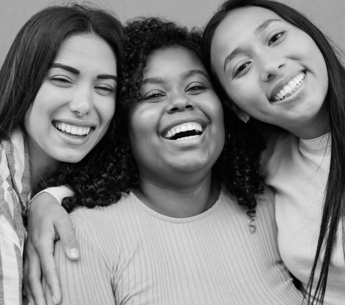 Three young women smiling together
