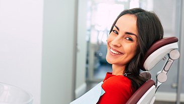 A beautiful, smiling woman sitting in a dentist’s chair