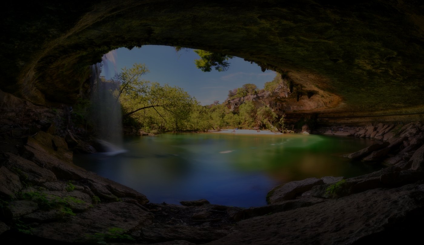 Small pond with waterfall next to a cave