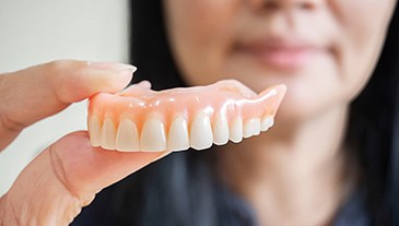 Woman holding denture