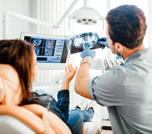 a dentist showing a patient her X-ray