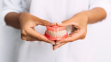Lady presents viewer with dentures