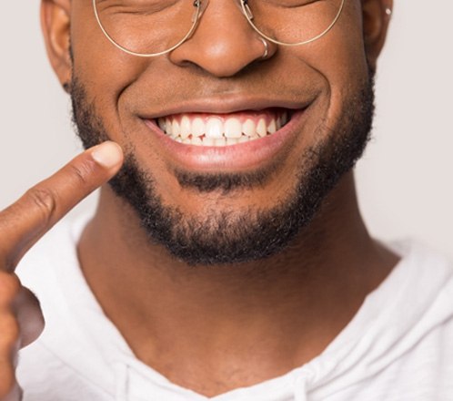 Closeup of man pointing to his dental implants in Lakeway