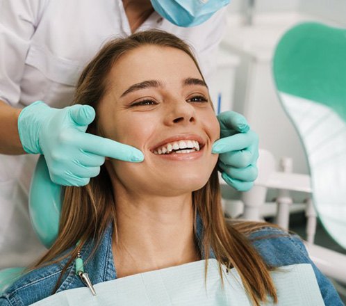 a patient checking her smile with a mirror