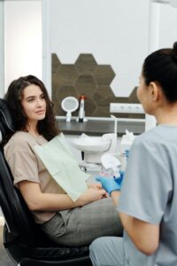 Female dental patient speaking with dentist