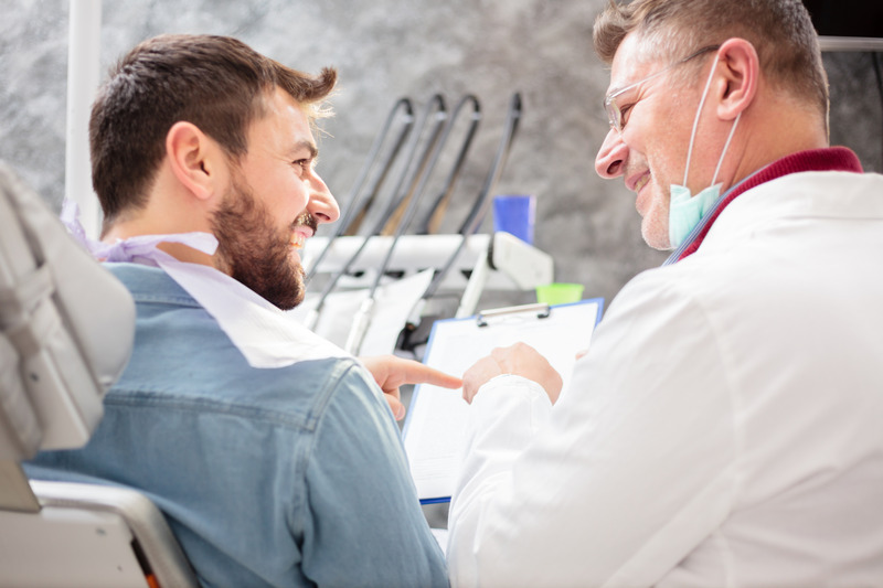 Dentist smiling with patient at dental checkup
